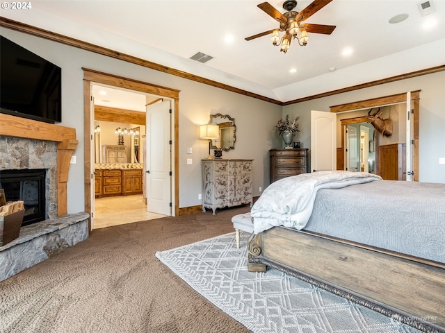 bedroom featuring carpet flooring, ensuite bath, ceiling fan, a fireplace, and ornamental molding