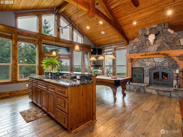 kitchen with pendant lighting, pool table, dark stone counters, and hardwood / wood-style floors