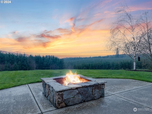 patio terrace at dusk with a lawn and an outdoor fire pit