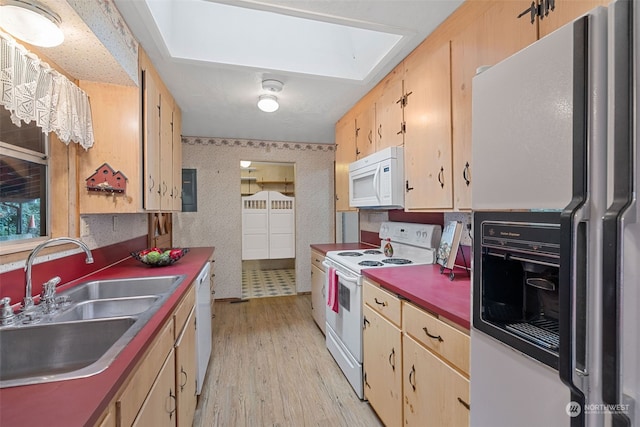 kitchen featuring light brown cabinetry, a skylight, white appliances, sink, and light hardwood / wood-style floors