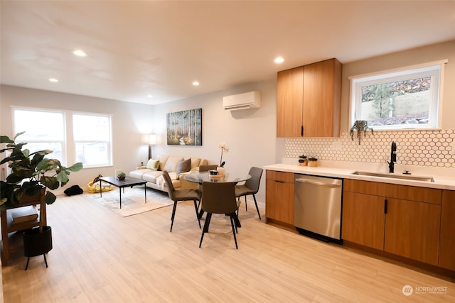 kitchen featuring sink, a wall mounted air conditioner, stainless steel dishwasher, light hardwood / wood-style floors, and decorative backsplash