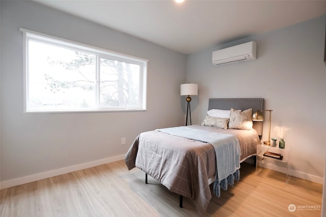 bedroom with a wall unit AC and hardwood / wood-style flooring