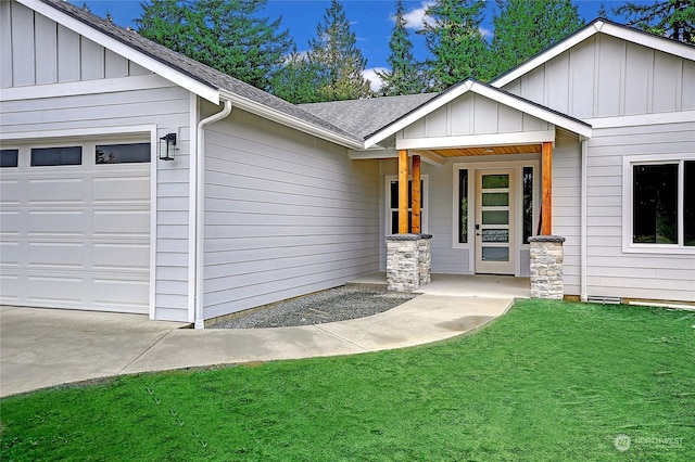 doorway to property with a porch, a garage, and a lawn