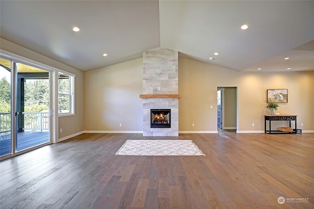 unfurnished living room featuring wood-type flooring, lofted ceiling, and a tile fireplace