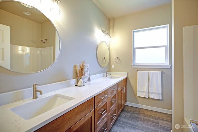 bathroom featuring wood-type flooring, vanity, and walk in shower