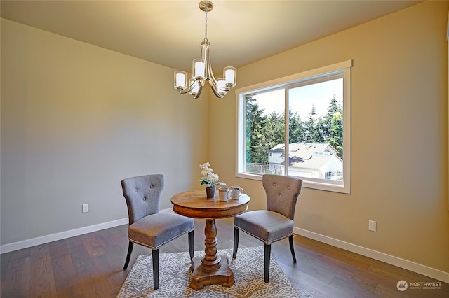 dining area with hardwood / wood-style floors and an inviting chandelier