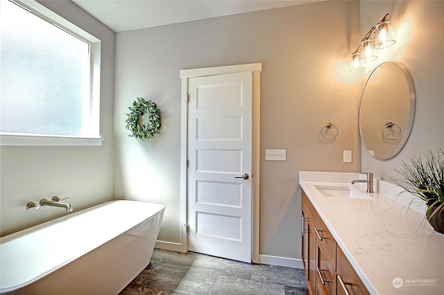 bathroom with a bathtub, vanity, and hardwood / wood-style flooring