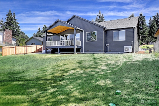 back of property with ac unit and a yard