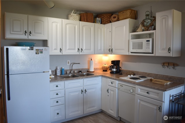 kitchen featuring white cabinetry, sink, white appliances, and light wood-type flooring