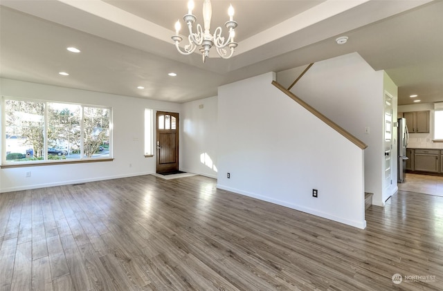 unfurnished living room with dark hardwood / wood-style flooring and an inviting chandelier