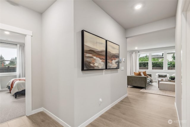 hall featuring recessed lighting, light wood-type flooring, and baseboards