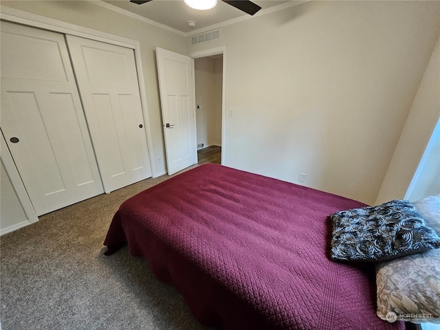 carpeted bedroom with a closet, ceiling fan, and ornamental molding