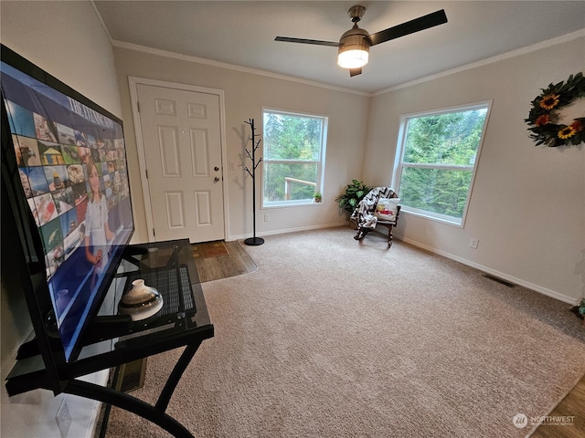 living area with crown molding, carpet floors, and ceiling fan