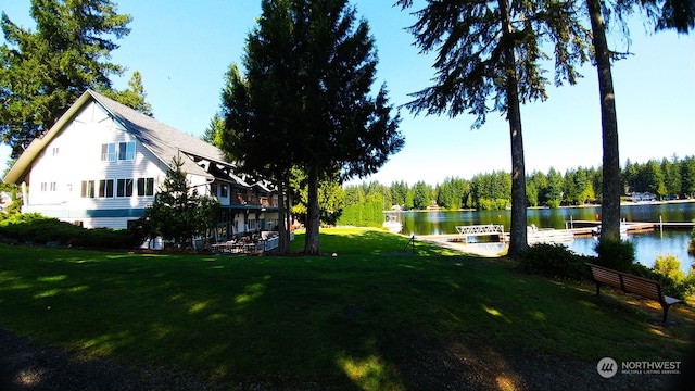 view of yard with a boat dock and a water view