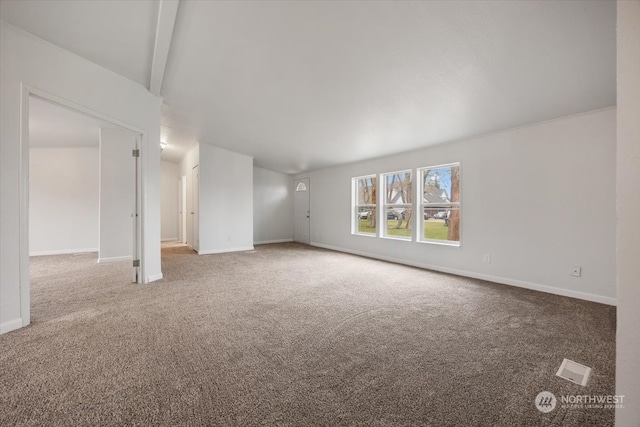 unfurnished living room featuring beam ceiling and carpet