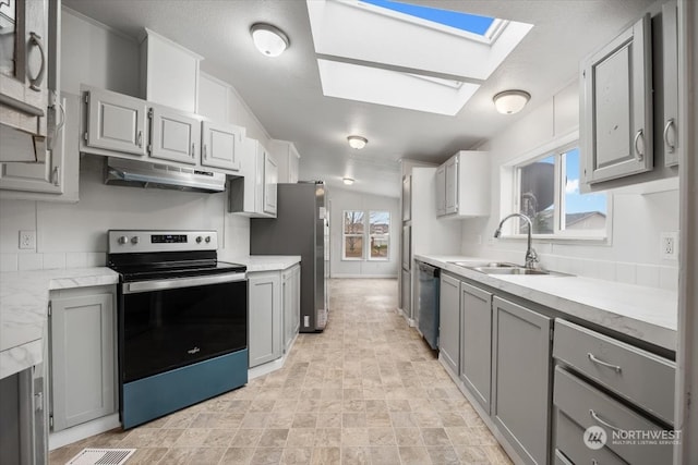 kitchen featuring appliances with stainless steel finishes, plenty of natural light, and gray cabinetry