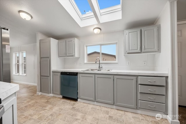 kitchen with gray cabinets, a skylight, sink, and stainless steel appliances