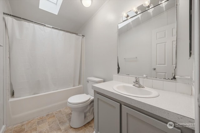 full bathroom featuring a skylight, toilet, shower / tub combo with curtain, vanity, and ornamental molding