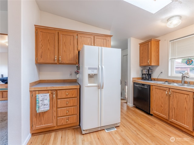 kitchen with vaulted ceiling, sink, black dishwasher, light wood-type flooring, and white fridge with ice dispenser