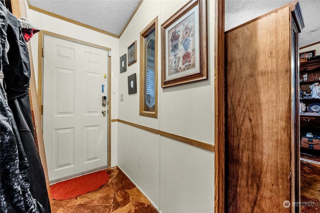 doorway to outside with a textured ceiling and ornamental molding