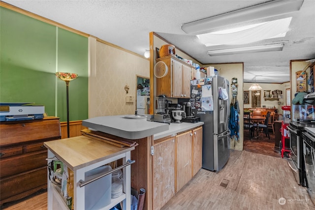 kitchen featuring light hardwood / wood-style flooring, stainless steel appliances, and a textured ceiling