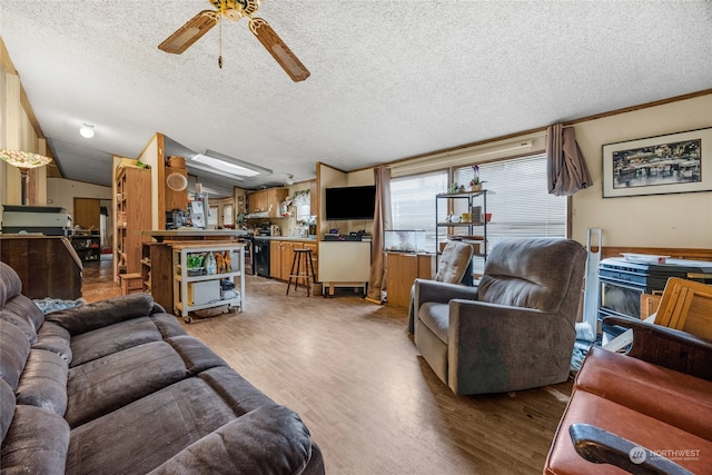 living room with wood-type flooring, a textured ceiling, and ceiling fan