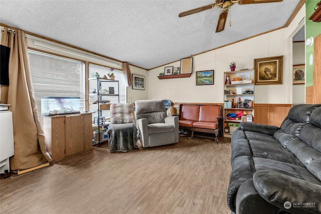 living room with a textured ceiling, hardwood / wood-style flooring, crown molding, and lofted ceiling