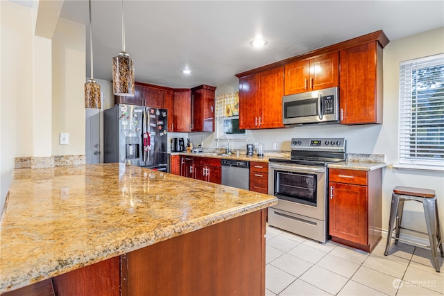 kitchen featuring sink, light tile patterned floors, light stone counters, kitchen peninsula, and stainless steel appliances