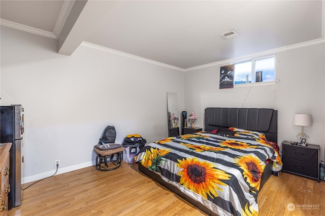 bedroom with ornamental molding, light hardwood / wood-style flooring, and fridge