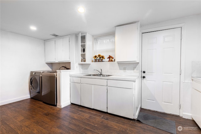 clothes washing area featuring dark hardwood / wood-style floors, cabinets, separate washer and dryer, and sink