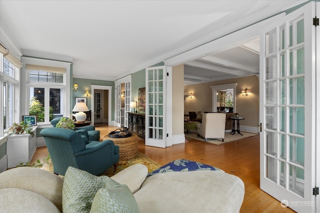 sunroom featuring beam ceiling and french doors