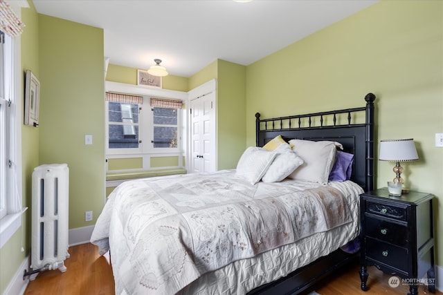 bedroom featuring hardwood / wood-style floors, a closet, and radiator