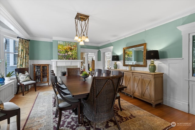 dining space with light hardwood / wood-style floors, plenty of natural light, and ornamental molding