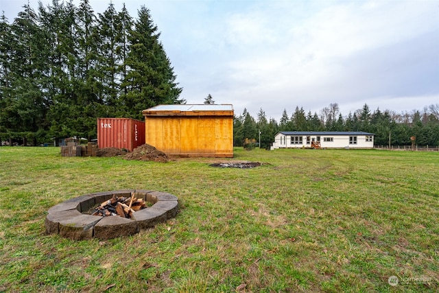 view of yard with a fire pit and an outbuilding