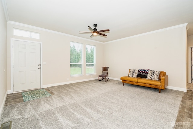 sitting room featuring ceiling fan, carpet floors, and ornamental molding