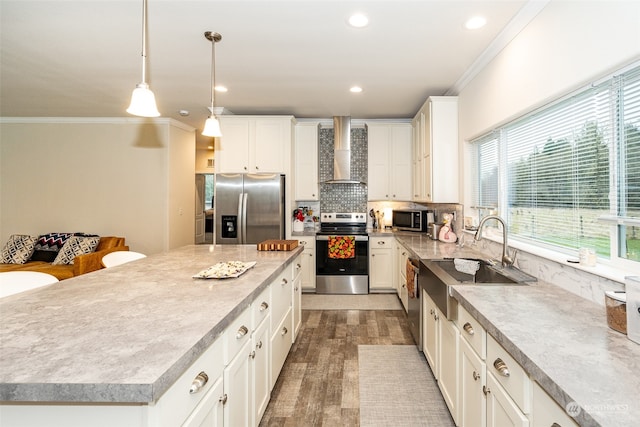 kitchen featuring white cabinetry, a kitchen island, stainless steel appliances, and wall chimney range hood