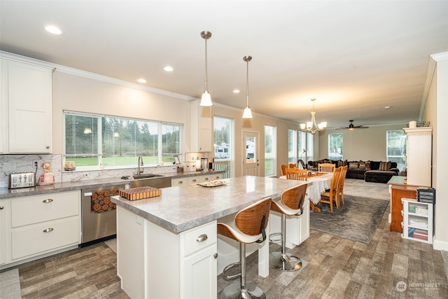 kitchen featuring white cabinets, tasteful backsplash, sink, dishwasher, and a center island