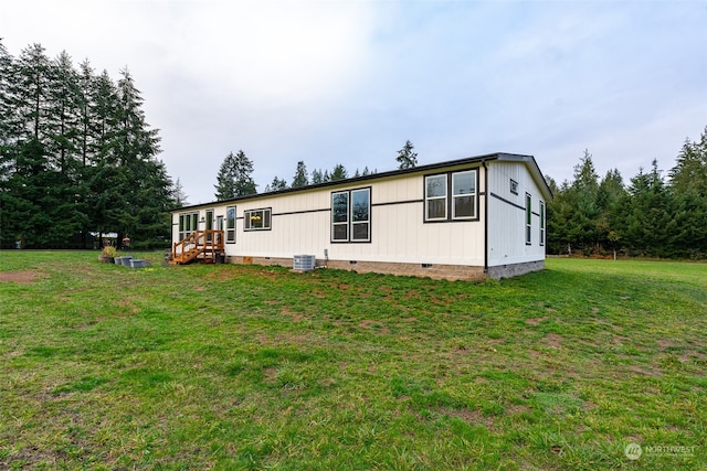 view of property exterior with a lawn and central AC unit