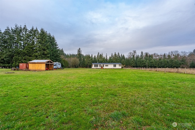 view of yard with a rural view and an outdoor structure