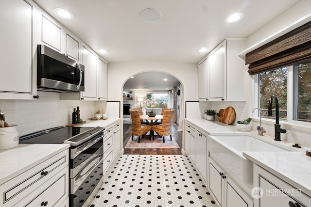 kitchen featuring a healthy amount of sunlight, white cabinets, and stainless steel appliances