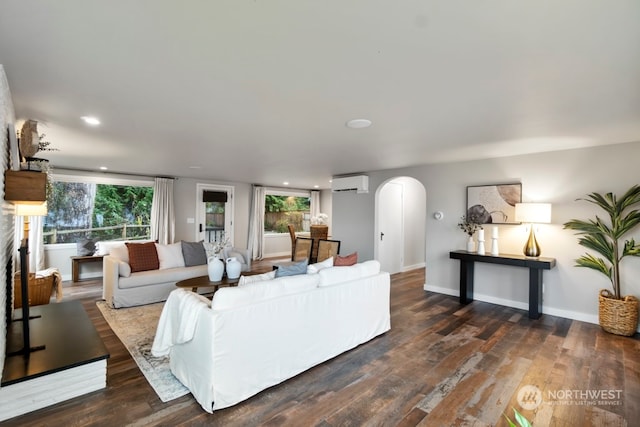 living room with an AC wall unit and dark hardwood / wood-style flooring