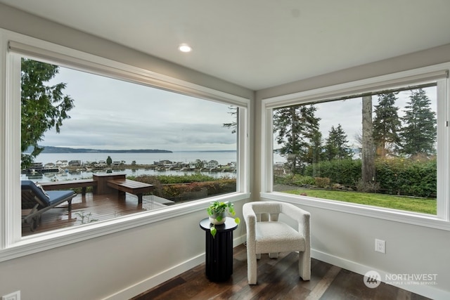 sunroom / solarium with a water view and a healthy amount of sunlight