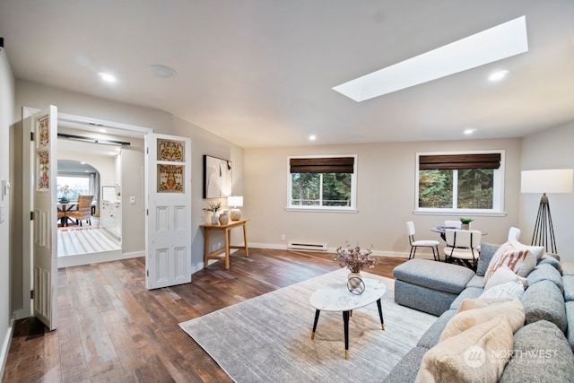 living room featuring a skylight, a baseboard radiator, and dark hardwood / wood-style floors