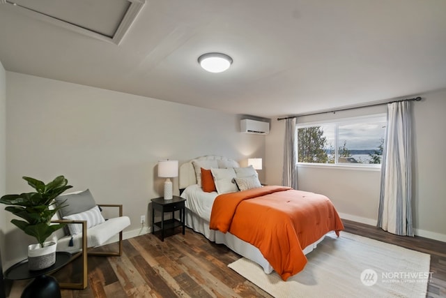 bedroom featuring dark hardwood / wood-style floors and a wall unit AC