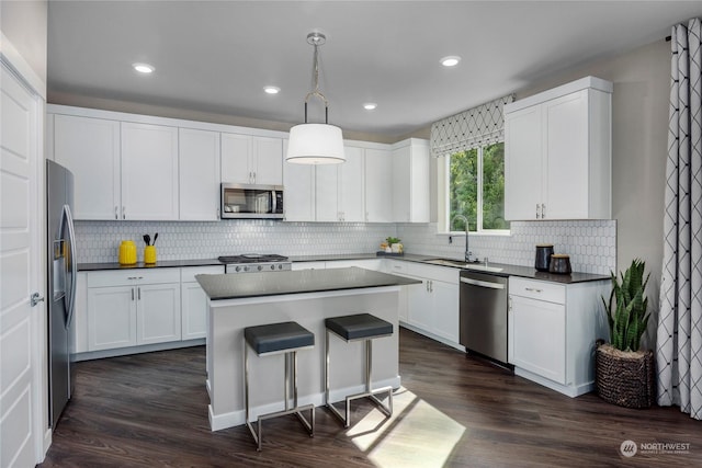 kitchen with pendant lighting, stainless steel appliances, and white cabinetry