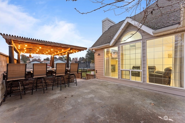 view of patio featuring a pergola, a trampoline, and an outdoor bar