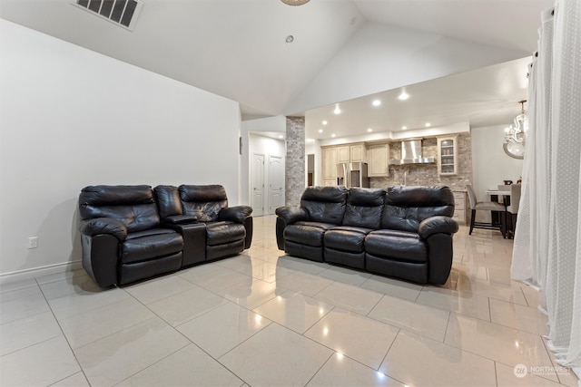 living room featuring decorative columns, light tile patterned floors, and high vaulted ceiling