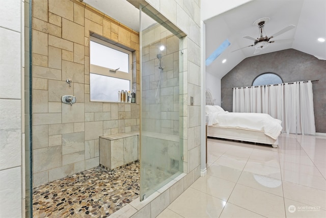 bathroom with a tile shower, ceiling fan, tile patterned flooring, lofted ceiling, and tile walls