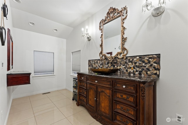 bathroom featuring tile patterned flooring, decorative backsplash, and vanity