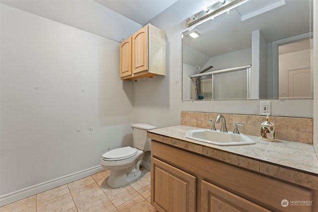 bathroom featuring tile patterned flooring, vanity, toilet, and an enclosed shower